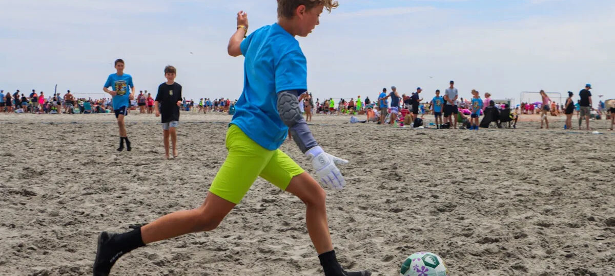 Kids play soccer in the sand during Cape Express Beach Blast